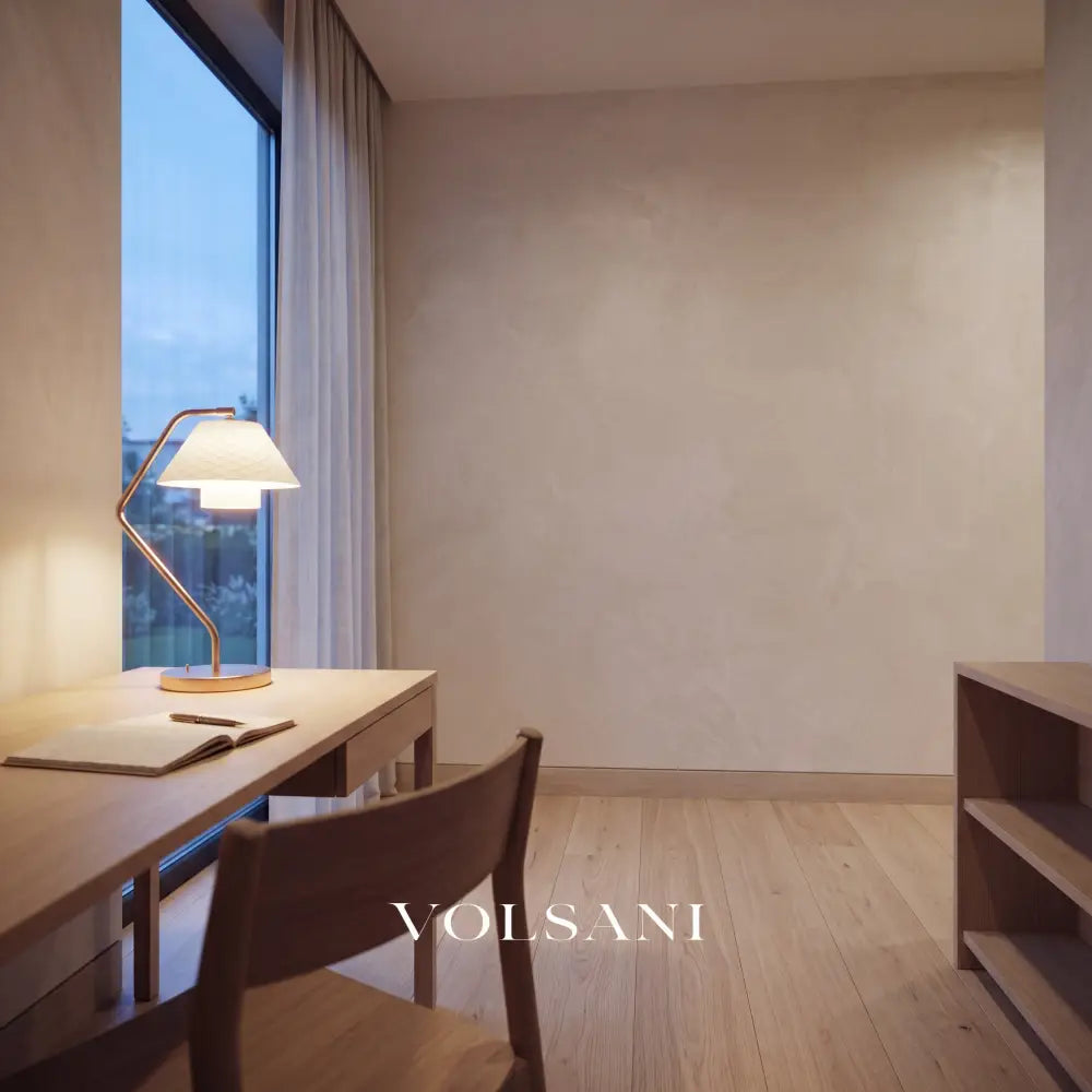 Ceramic lamp with copper frame and quilted shade lit on a desk in a Japandi study at dusk
