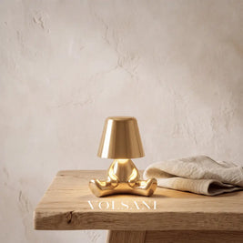Close-up of the gold figurine night light on raw oak against a plaster wall