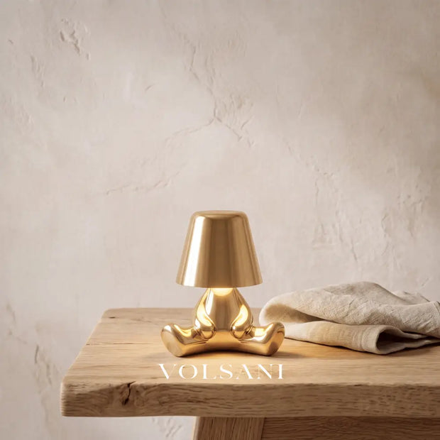 Close-up of the gold figurine night light on raw oak against a plaster wall