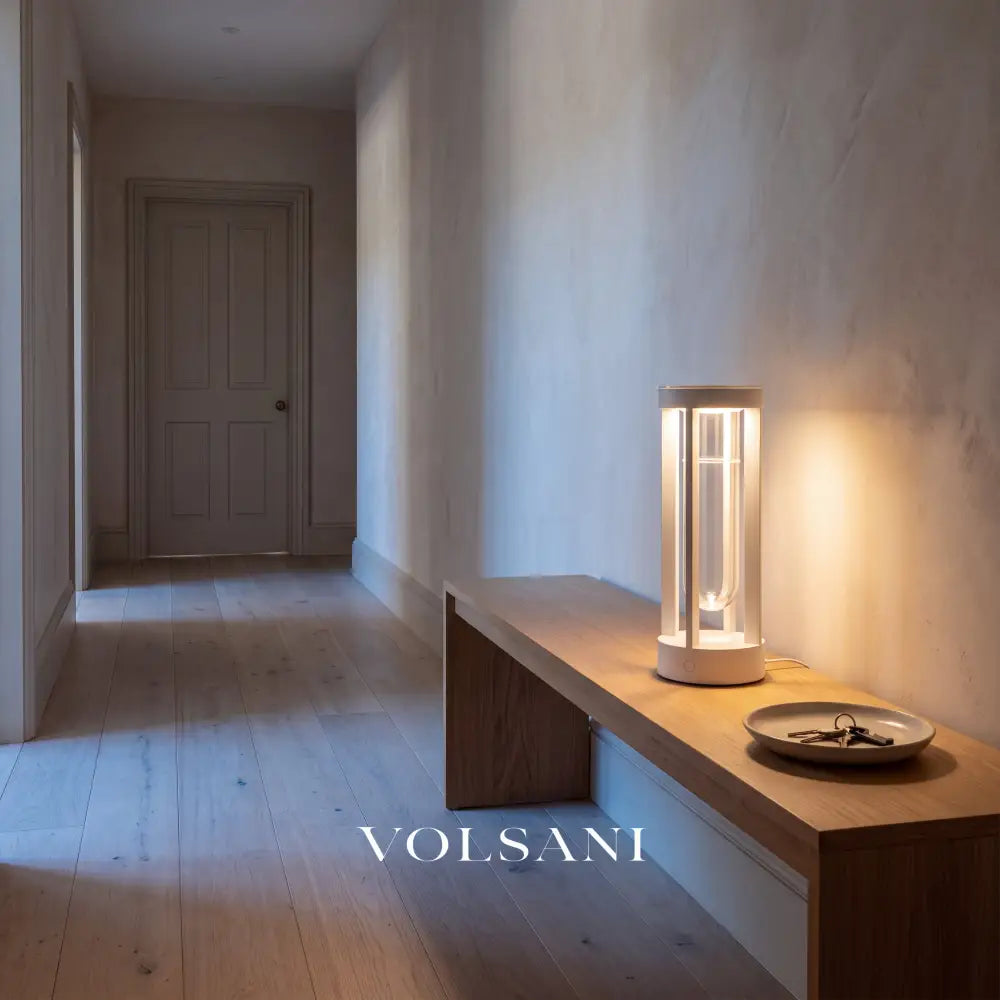 White built-in-vase lamp lit on a console in a Japandi hallway at dusk