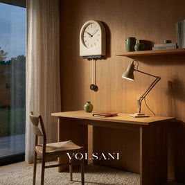 JOOST cream pendulum wall clock in white face above a desk in a study
