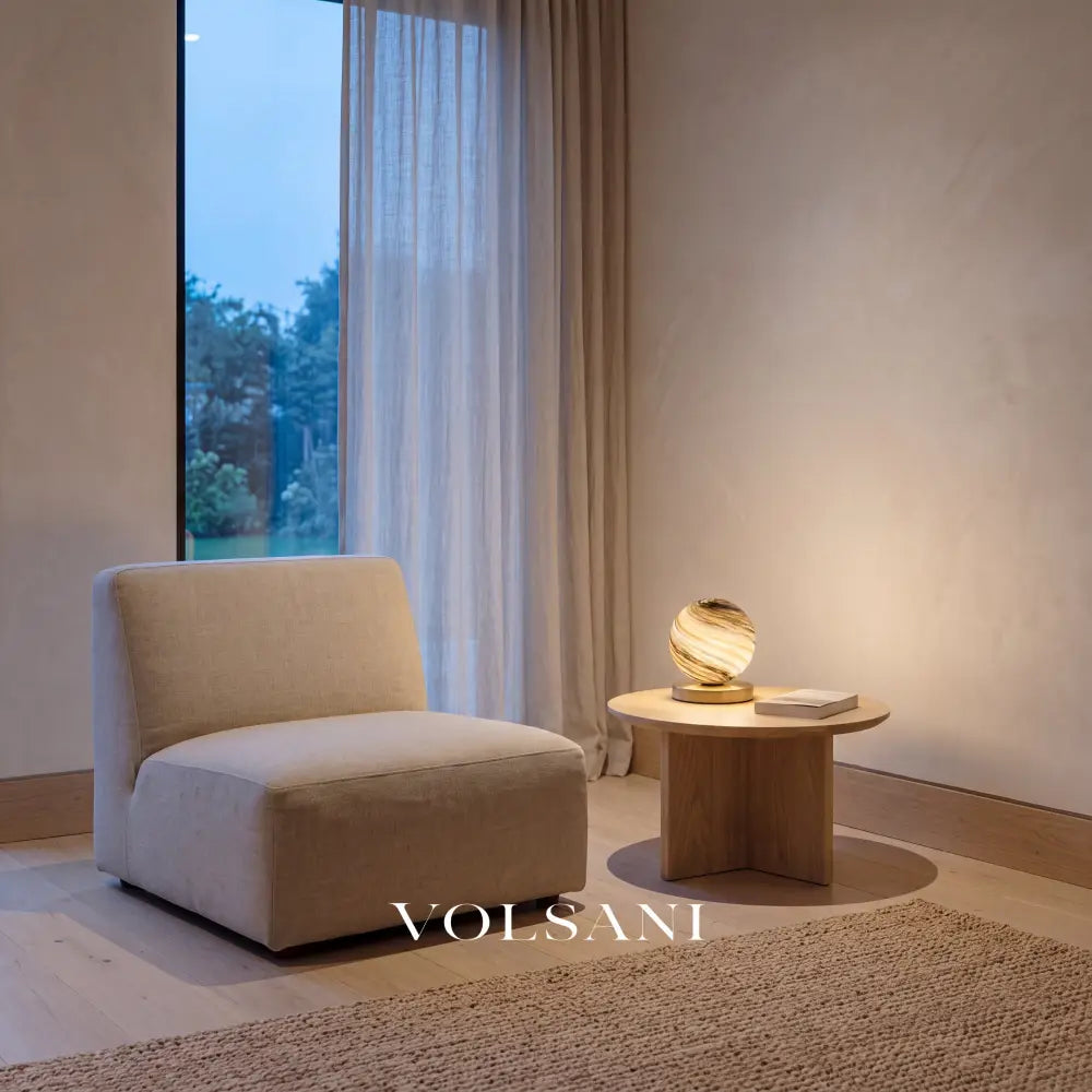 Marbled glass globe lamp with brass base lit in a Japandi reading nook at dusk