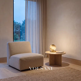 Marbled glass globe lamp with brass base lit in a Japandi reading nook at dusk
