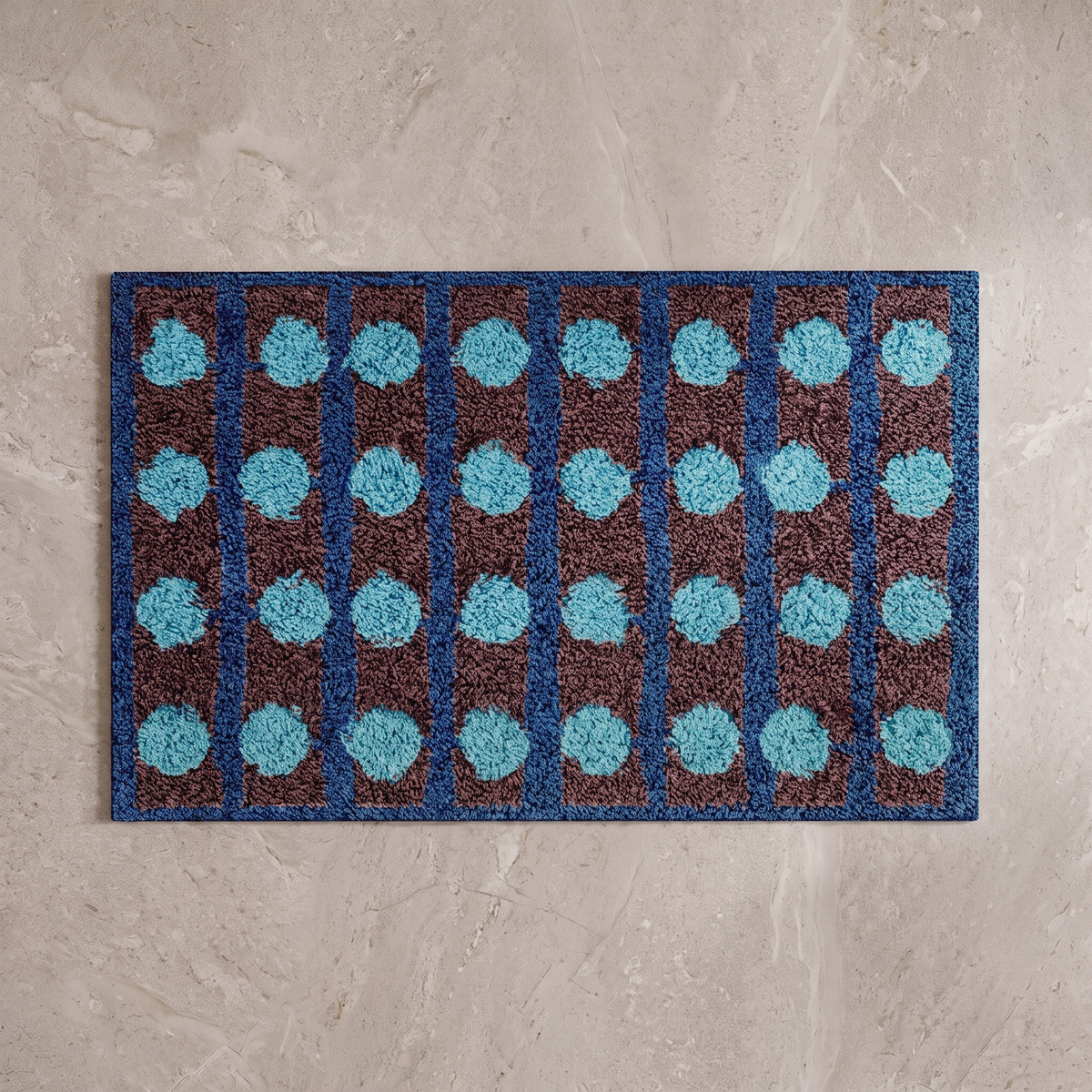 Mechanical Rainbow Bauhaus bath mat, overhead on stone floor