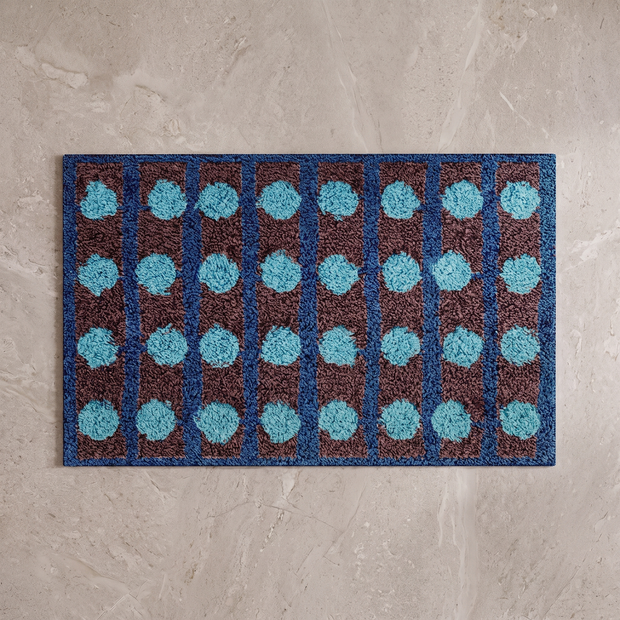 Mechanical Rainbow Bauhaus bath mat, overhead on stone floor