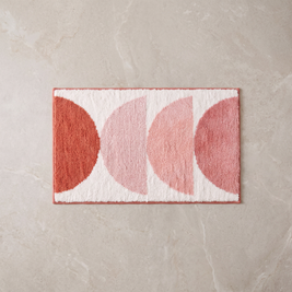 Pink Sunset gradient bath mat, overhead on stone floor