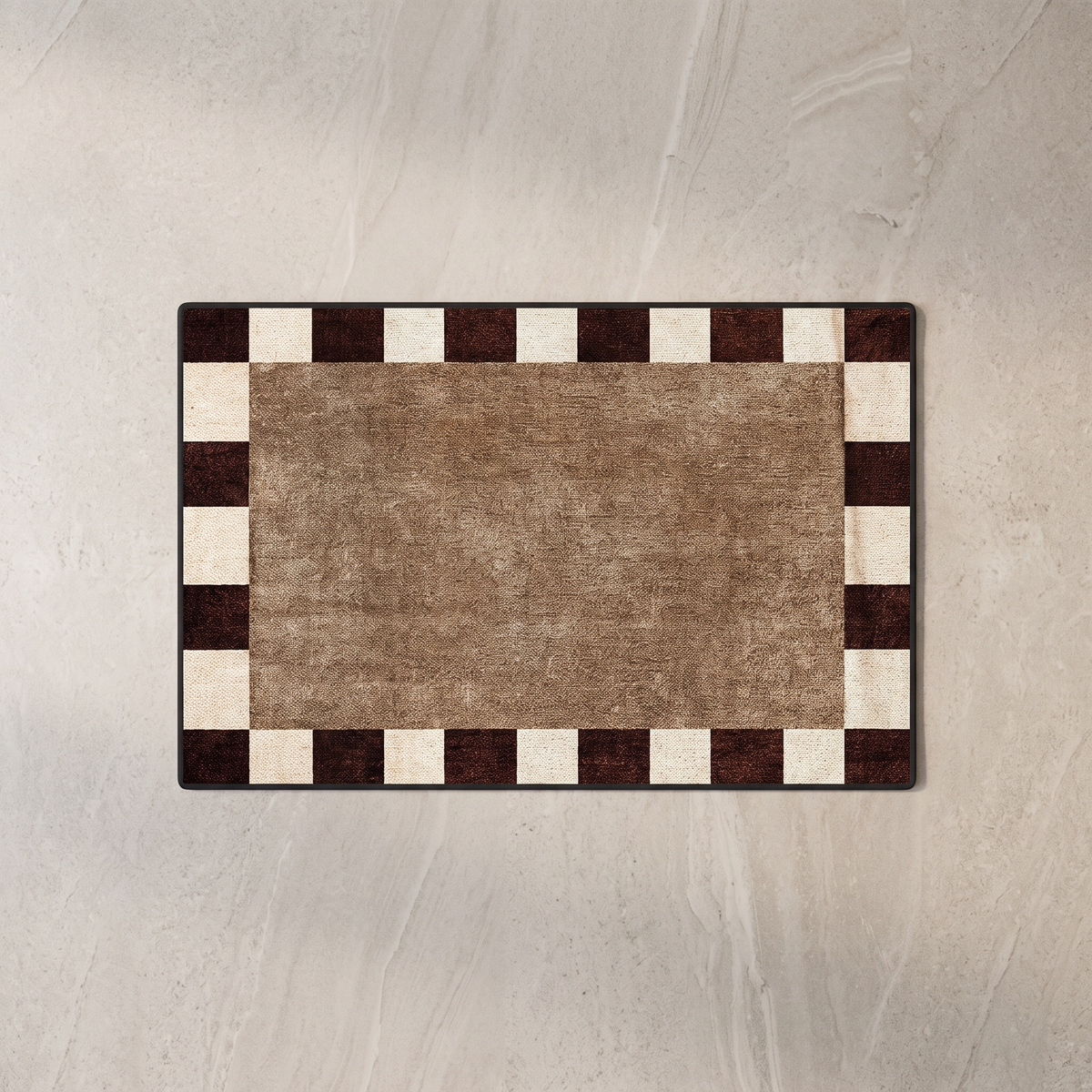 Tan bath mat with dark border, overhead on stone floor