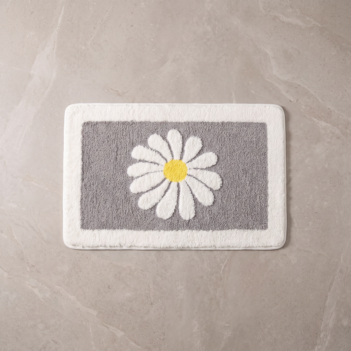 Grey Bloom daisy bath mat, overhead on stone floor