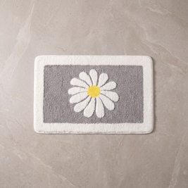 Grey Bloom daisy bath mat, overhead on stone floor