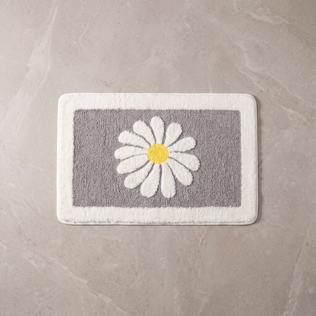 Grey Bloom daisy bath mat, overhead on stone floor