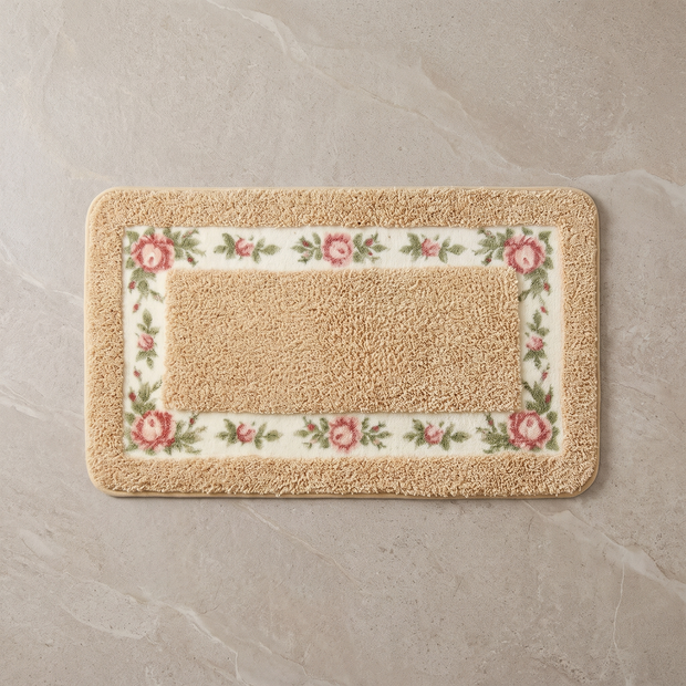 Golden Rose floral border bath mat, overhead on stone floor