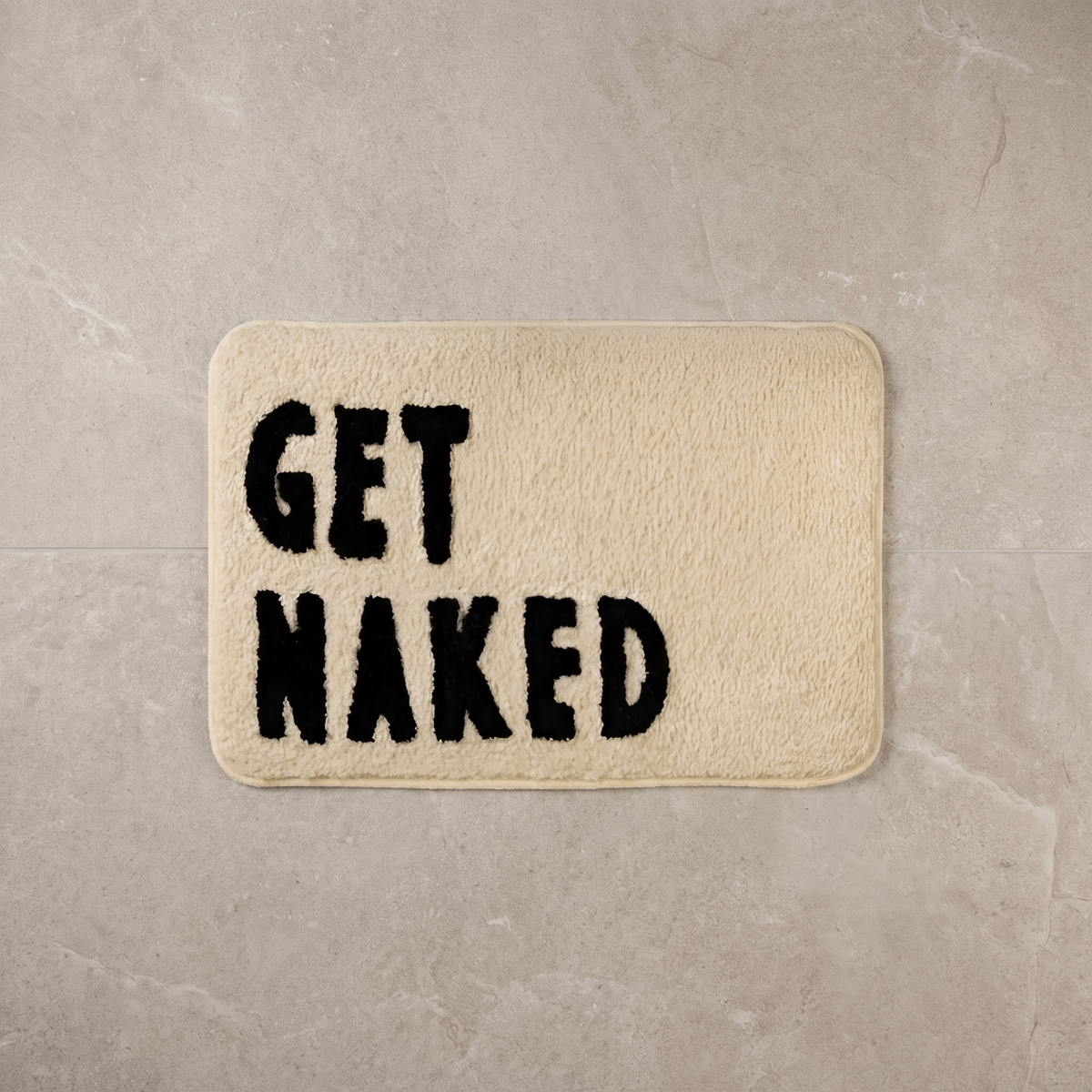 Bare Statement fluffy bath mat, overhead on stone floor