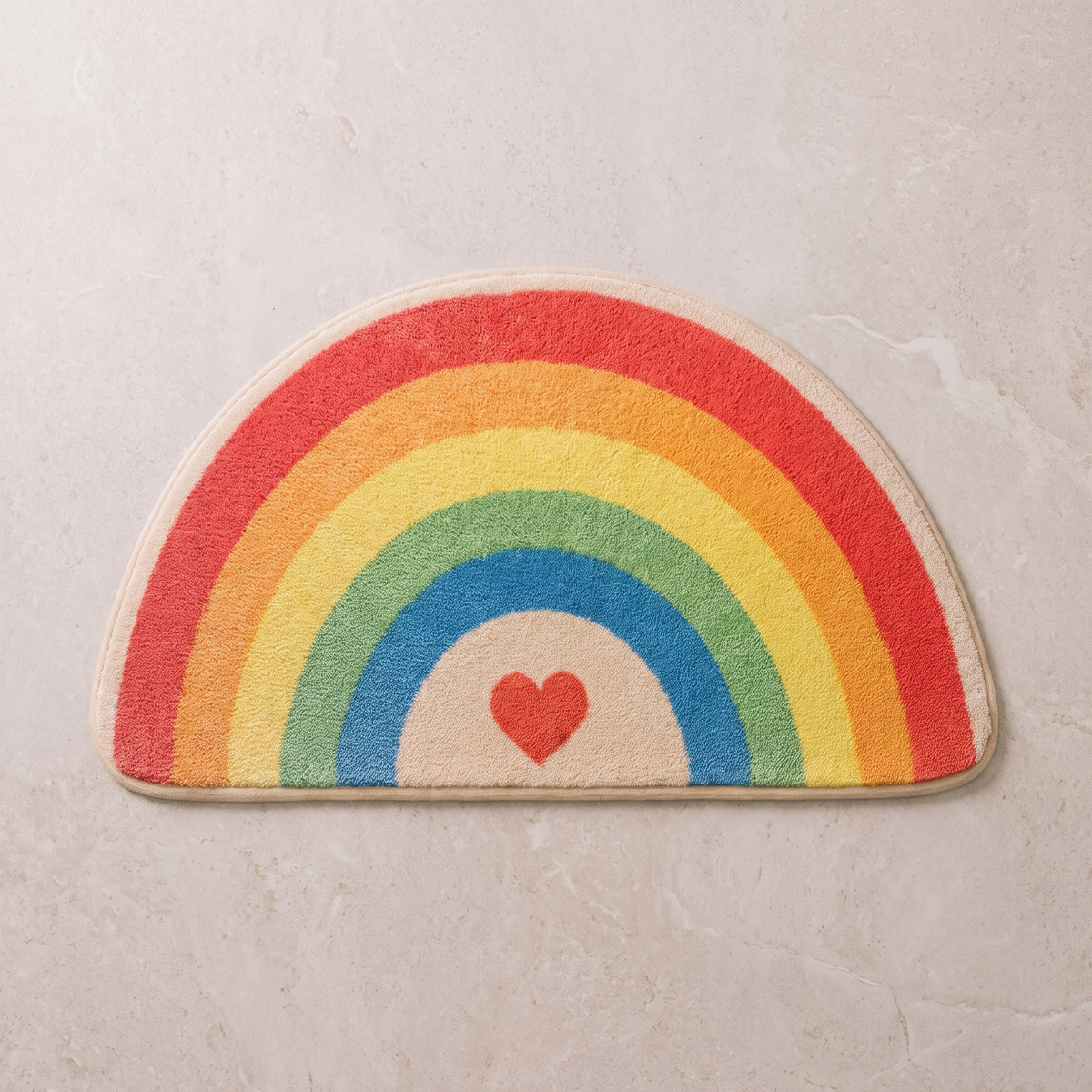 Heart Glow half moon bath mat, overhead on stone floor