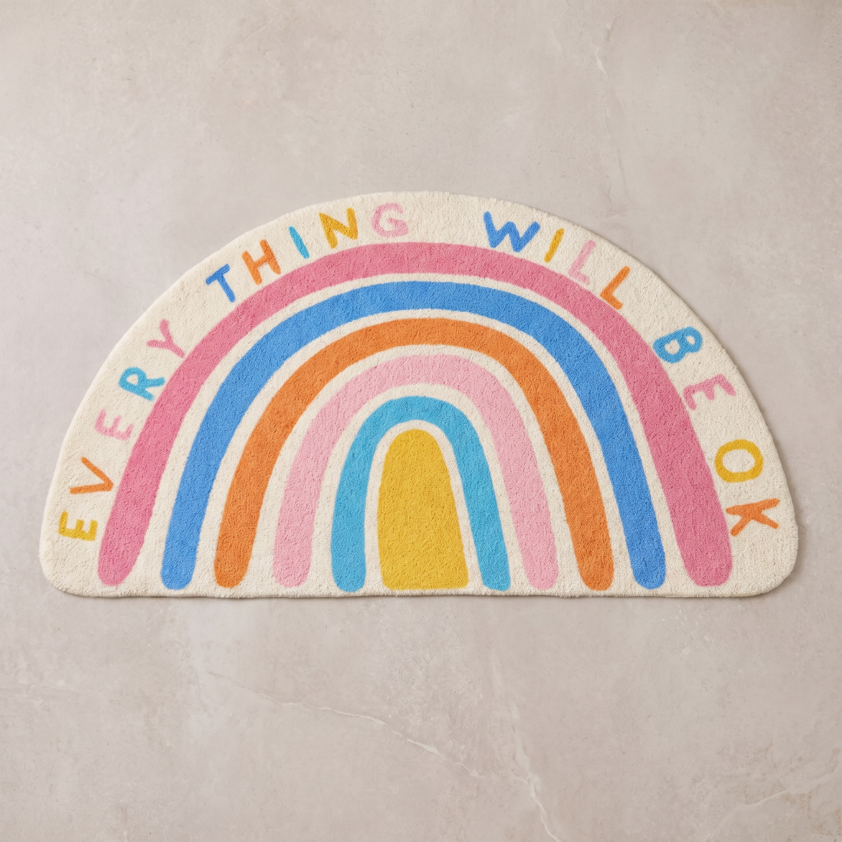 Positive Vibes half moon bath mat, overhead on stone floor