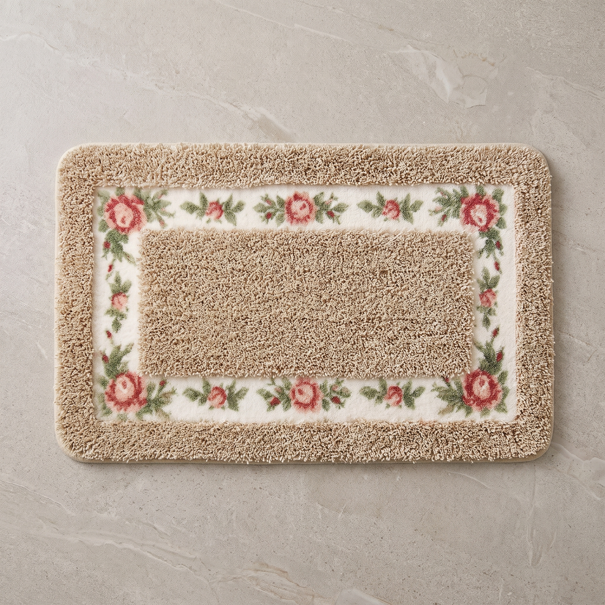 Sand Blossom floral border bath mat, overhead on stone floor