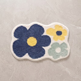 Bold Blossom tufted floral bath mat, overhead on stone floor