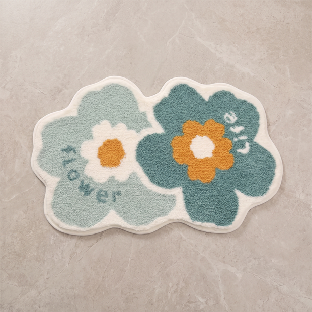 Whimsical Flower tufted floral bath mat, overhead on stone floor