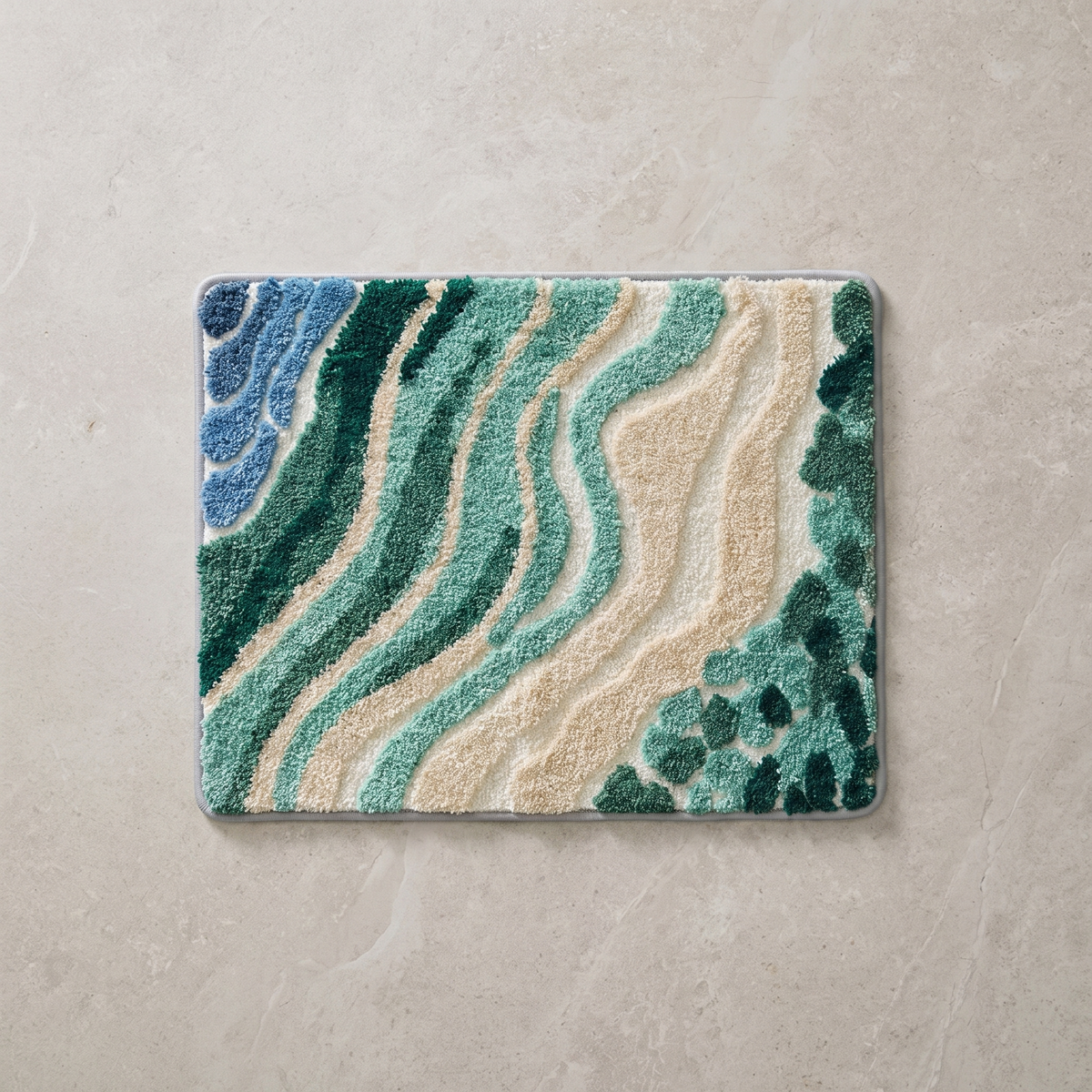 Wave pattern bath mat in blue and green, overhead on stone floor