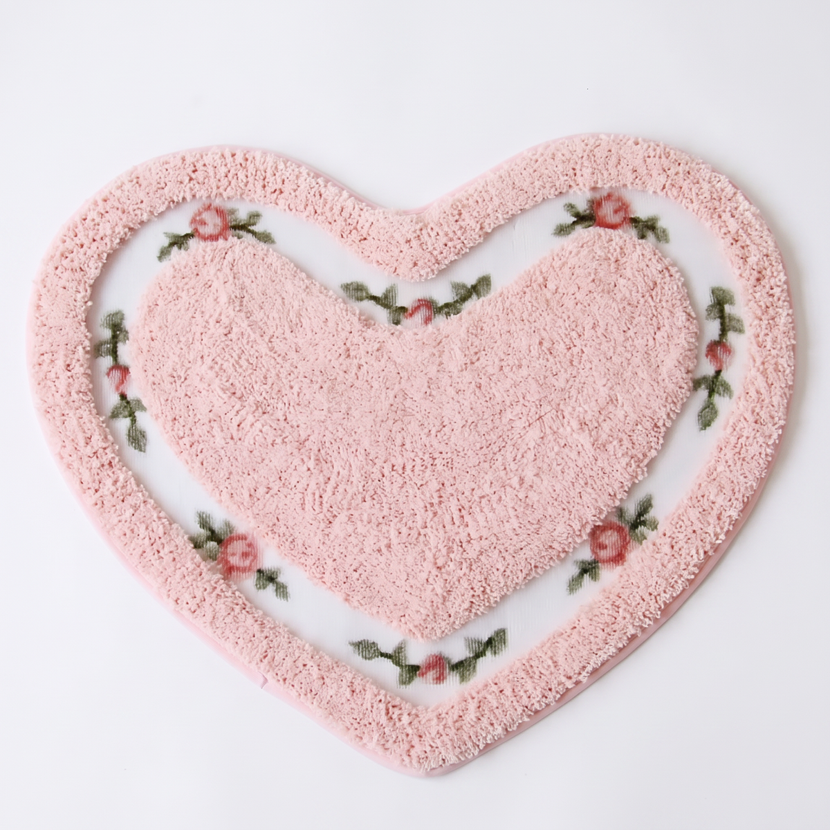 Heart shaped tufted bath mat on a white background, overhead
