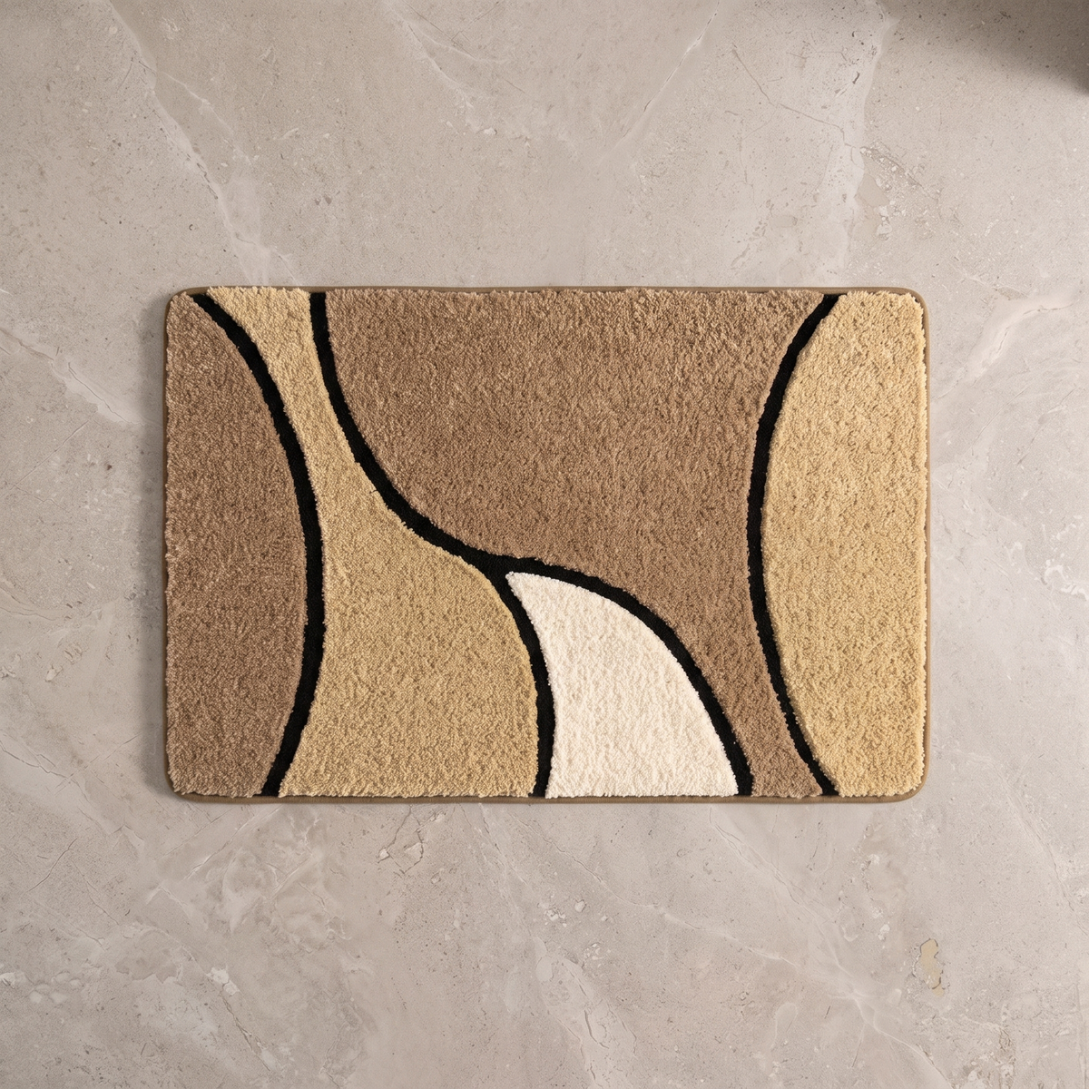 Sand Dune plush wave bath rug on a pale stone floor, overhead