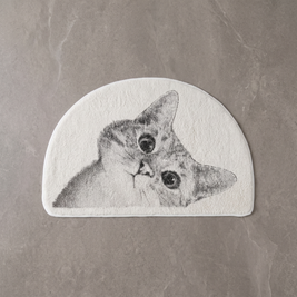 Curious Kitty cat bath mat on a pale stone floor, overhead