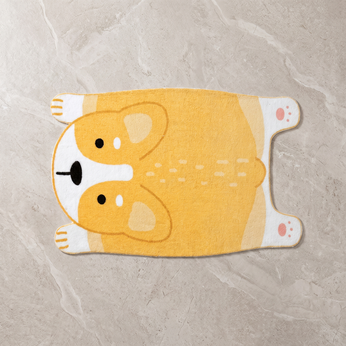 Yellow animal motif floor mat on a pale stone floor, overhead