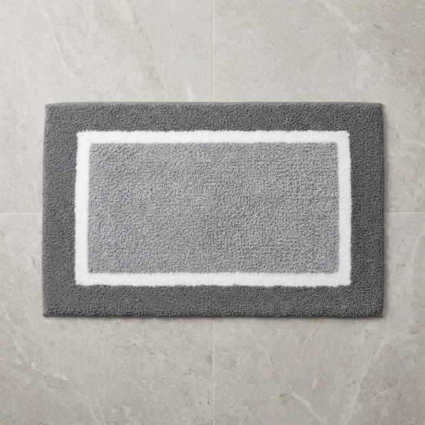 Black striped microfiber bath mat on stone floor, overhead