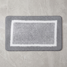 Beige striped microfiber bath mat on stone floor, overhead