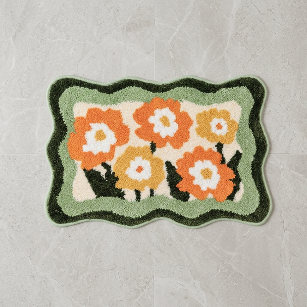 Green colorful floral bath mat on stone floor, overhead