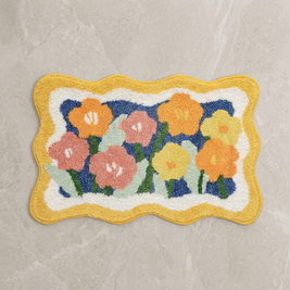Yellow colorful floral bath mat on stone floor, overhead