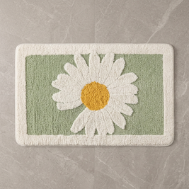 Sage Daisy plush bath mat on stone floor, overhead
