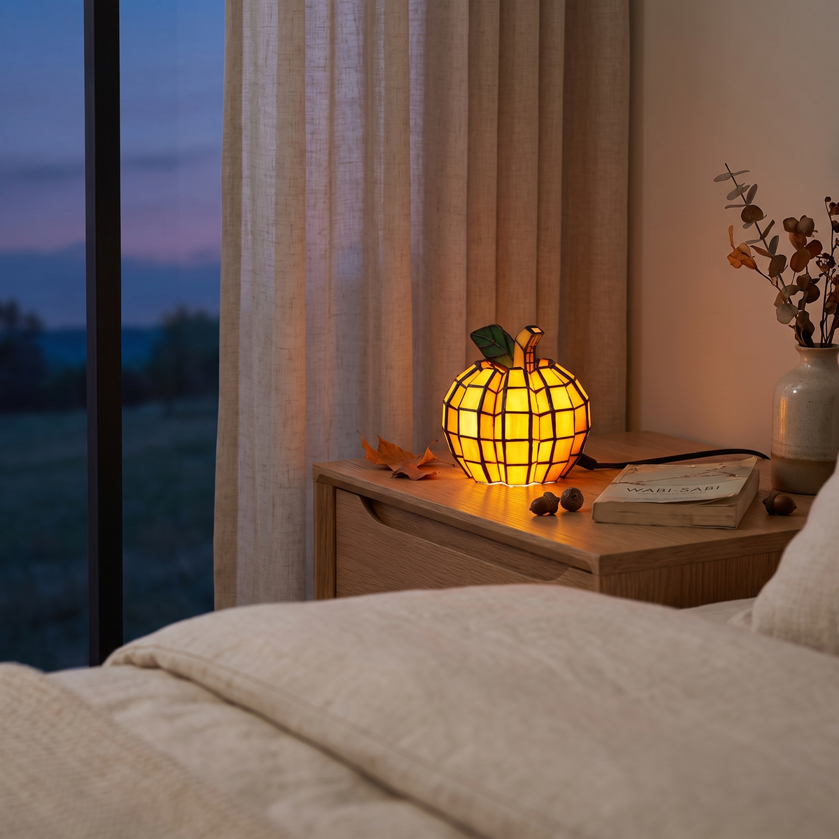 Stained glass pumpkin lamp on a bedside table at dusk