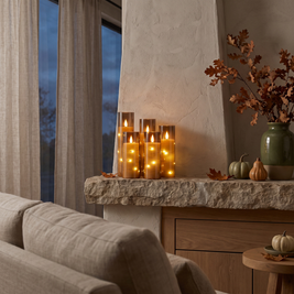 Flameless LED candles on a fireplace mantel at dusk