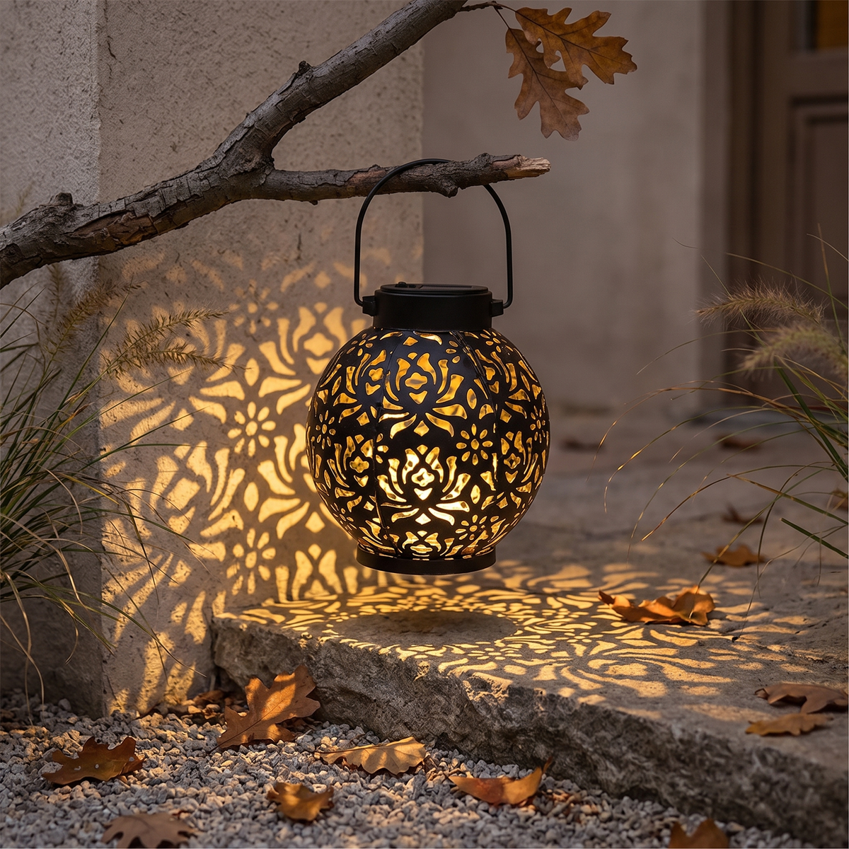 Iron cutout solar lantern casting patterns on a garden wall