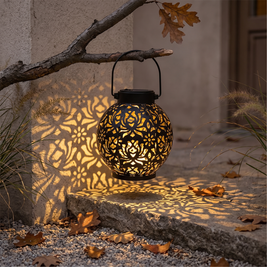 Iron cutout solar lantern casting patterns on a garden wall