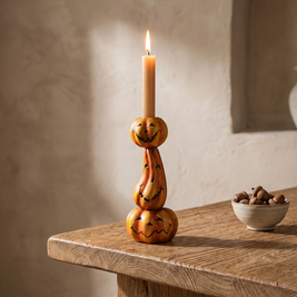 Stacked pumpkin candlestick with a lit taper