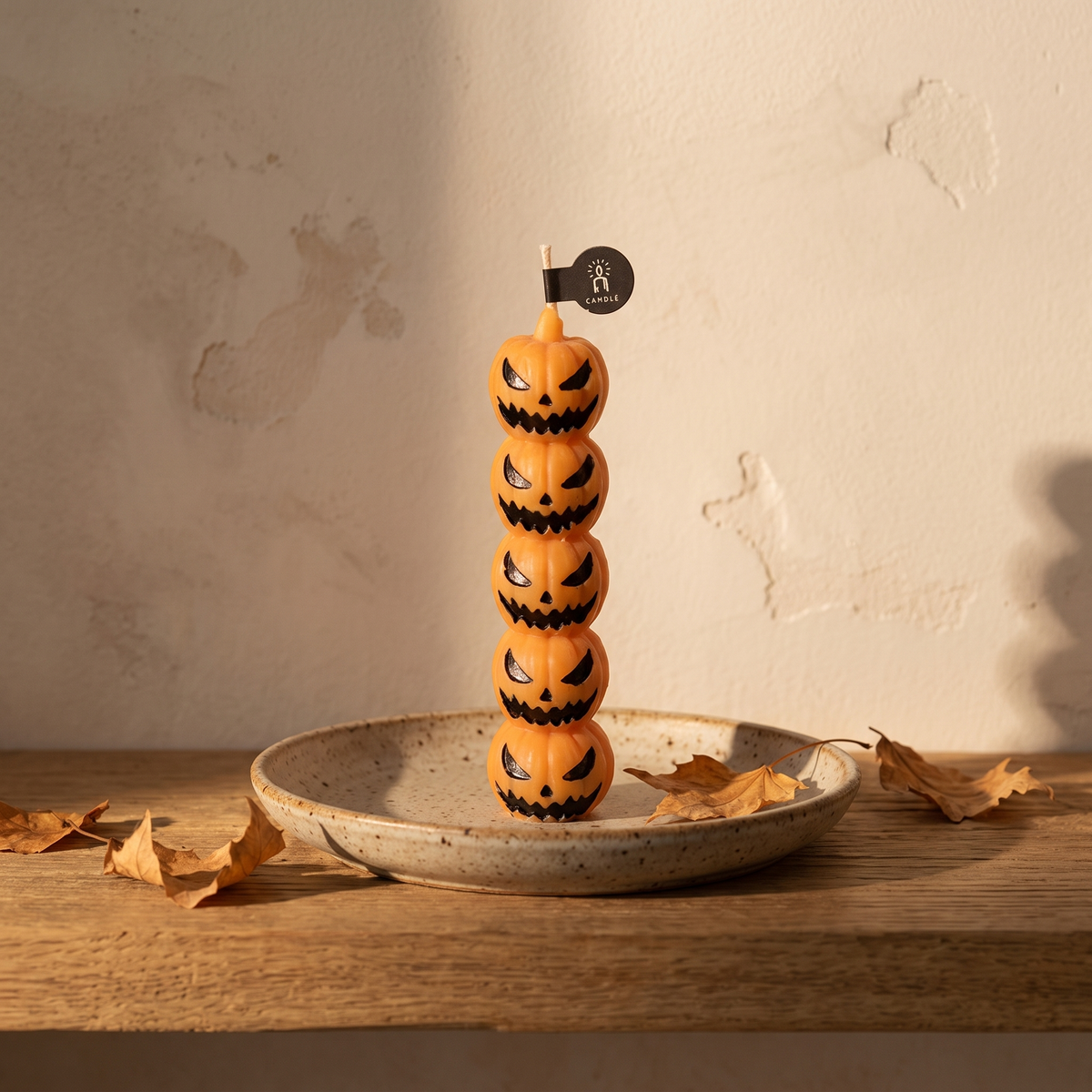 Figural Halloween candle on a stoneware dish