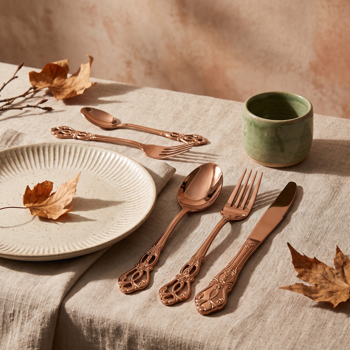 Rose gold baroque flatware place setting on a linen napkin