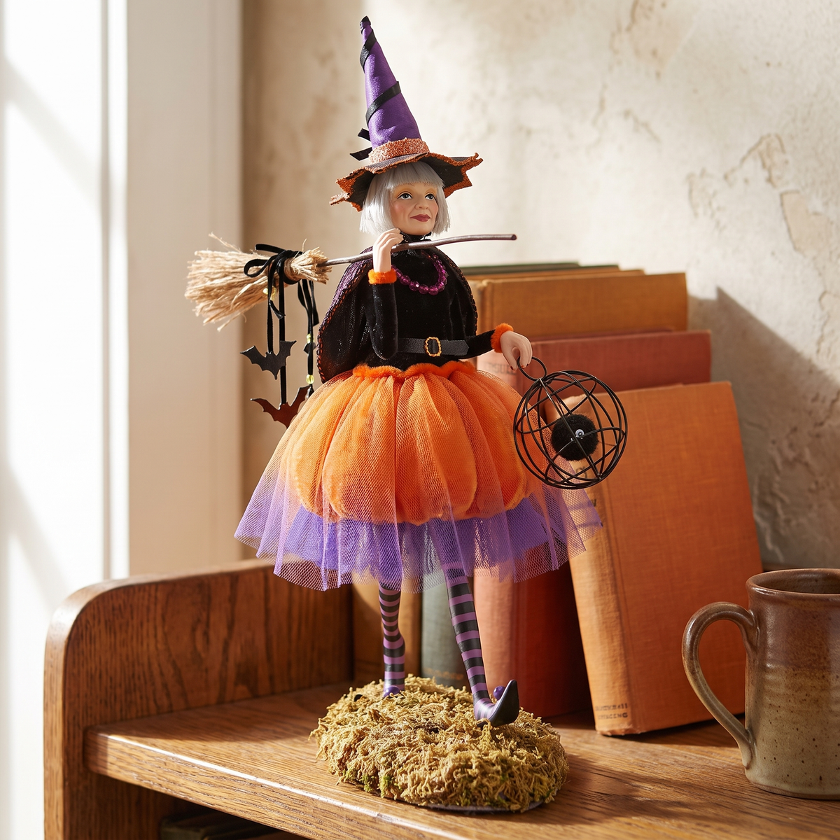 Daphne witch figurine close-up on an oak bookshelf