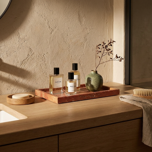 Red marble tray with perfume bottles on a Japandi bathroom vanity