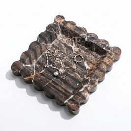 Dark brown scalloped travertine jewelry tray on white background