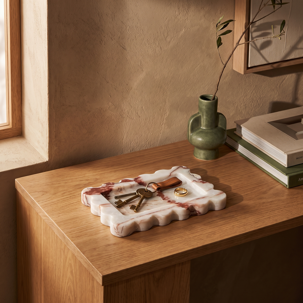 Rust scalloped marble tray with keys on an entryway console