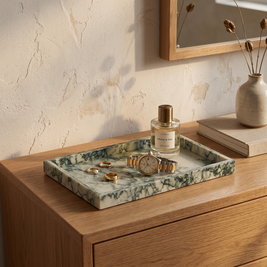 Green marble tray with rings and a watch on a bedroom dresser
