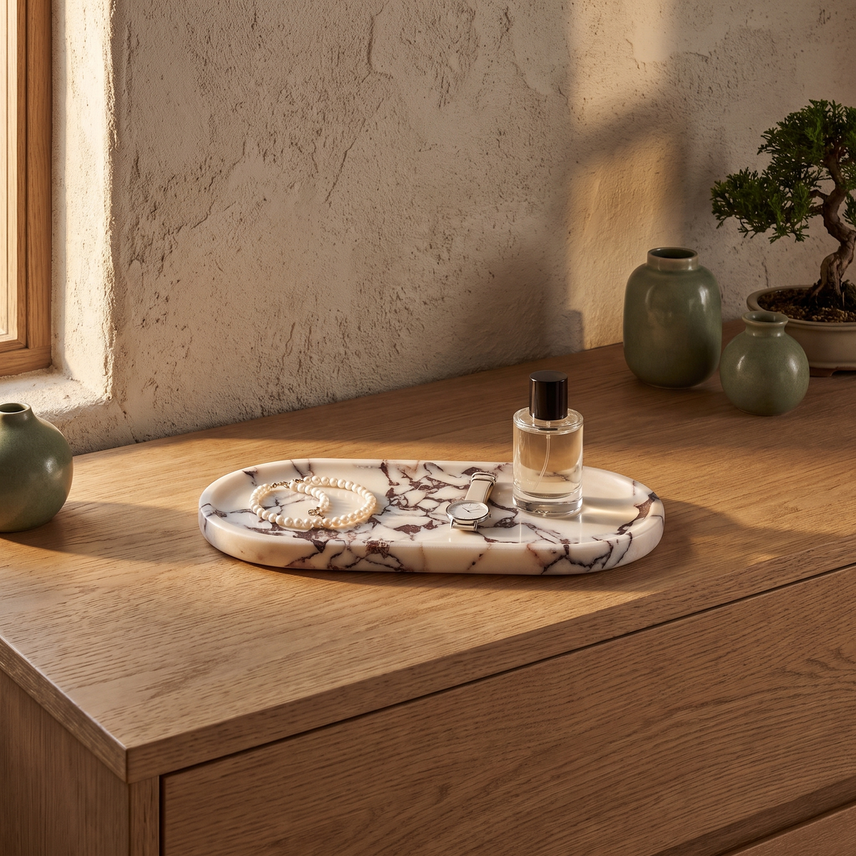 White marble vanity tray with pearls and a watch on a bedroom dresser