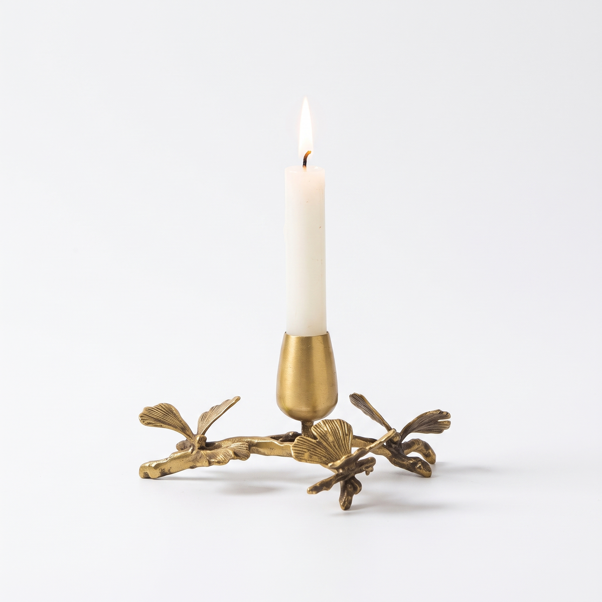 Brass ginkgo taper candle holder for 1 candle on white background