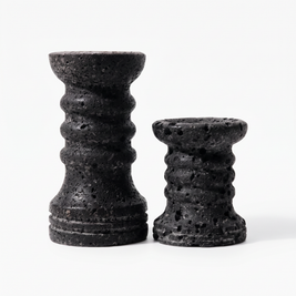 Set of two black ribbed travertine candle holders on white background