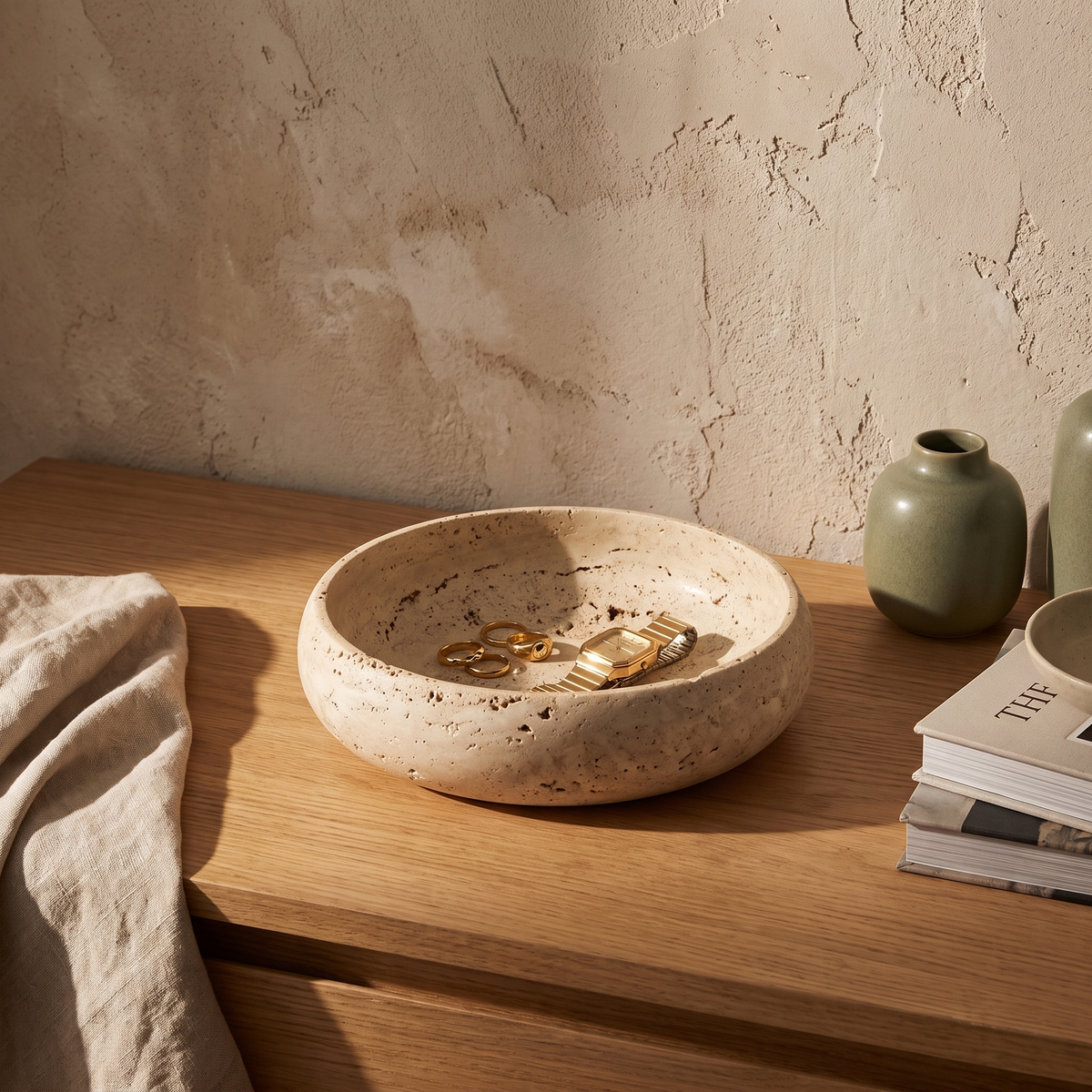 Round travertine-look marble catchall bowl styled on an oak bedroom dresser