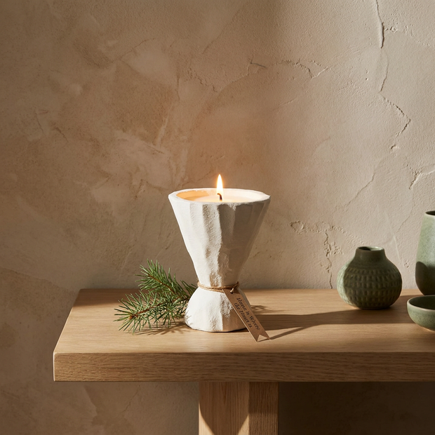 Concrete candle holder lit on an oak console