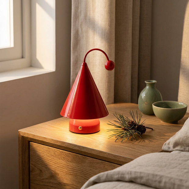 Rechargeable cordless cone table lamp close-up, on an oak nightstand, glowing warmly