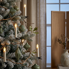 Clip on flameless LED Christmas tree candles close-up, clipped onto the branches of a Christmas tree